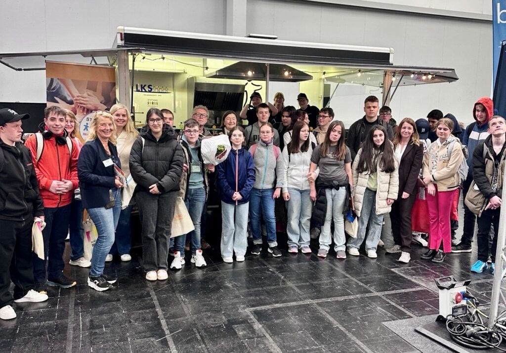 Gruppenbild –Schülergruppe am Messestand der LKS gGmbH